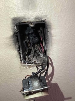 Burned electrical box with melted Wago wire connectors and charred wiring, showing severe overheating and fire damage.