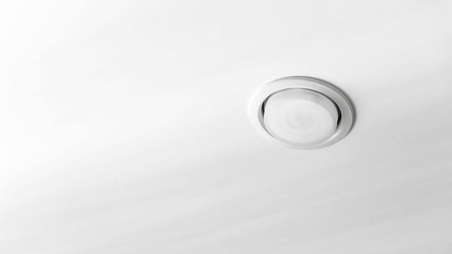 A recessed light fixture on a smooth white ceiling
